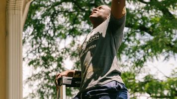 A Merus employee-owner painting a house for a service day project