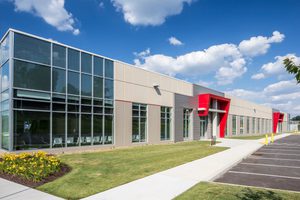Flex office with glass panels, red accents, and a beige concrete exterior