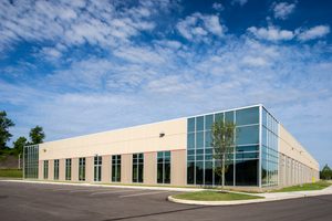 Side view of a flex office with large glass panels and beige concrete walls