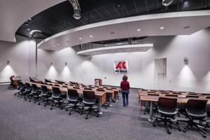 Large conference and training room with rows of desks, a podium, and the AK Steel logo on the front wall.