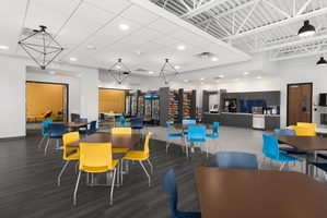 Bright office breakroom with colorful chairs, vending machines, and a modern open layout.