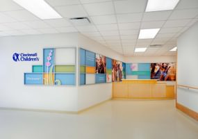 Cincinnati Childrens reception area with colorful wall decor, photos and the logo featured on the wall.