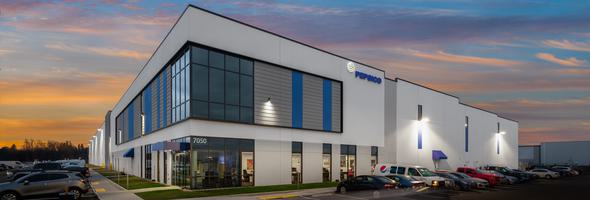 White industrial building with gray and blue accents and a glass facade. The PepsiCo logo is on the side.