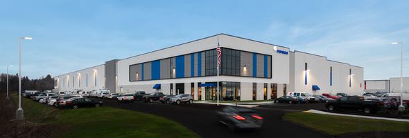 White industrial building with gray and blue accents and a glass facade. The PepsiCo logo is on the side.