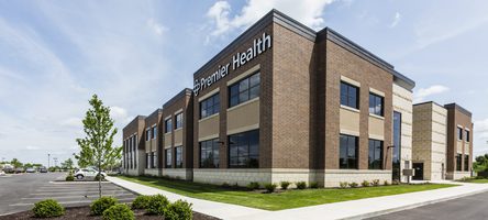 Corner view of building with brick exterior and beige accents. Premier Health logo is on top.