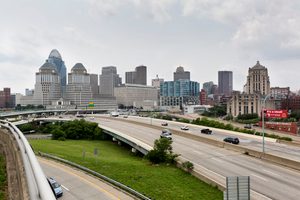 Cincinnati skyline featuring iconic buildings, highways, and green spaces.