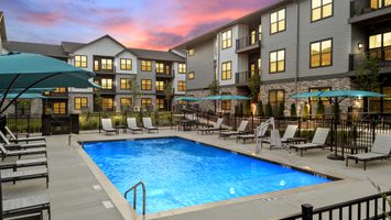 Pool with lounge chairs and green umbrellas